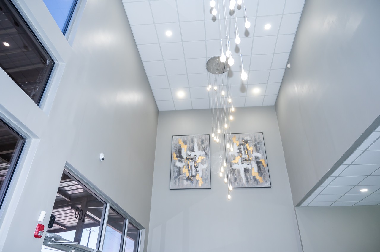 Cascading teardrop chandelier above paired abstract gold artworks in the lobby